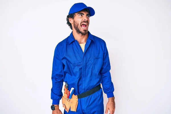 Jovem Bonito Com Cabelo Encaracolado Urso Weaing Handyman Uniforme Irritado — Fotografia de Stock