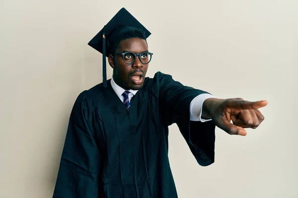 Mezuniyet Şapkası Tören Cübbesi Takan Yakışıklı Siyahi Bir Adam Parmağıyla — Stok fotoğraf