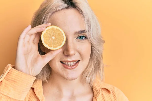Mladá Blondýnka Drží Citron Přes Oko Vypadá Pozitivní Šťastný Stojící — Stock fotografie