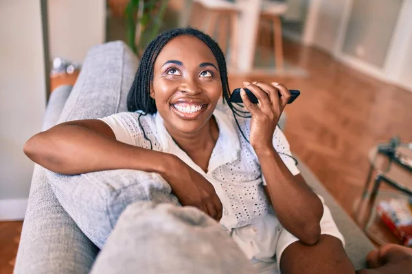 Joven Mujer Afroamericana Sonriendo Feliz Sentado Usando Teléfono Inteligente Casa —  Fotos de Stock