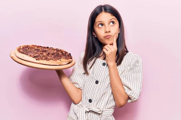 Menina Bonita Segurando Pizza Italiana Rosto Sério Pensando Sobre Pergunta — Fotografia de Stock