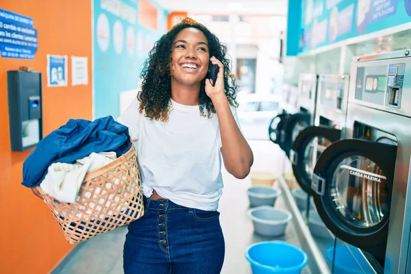 Młoda Afroamerykanka Kręconymi Włosami Uśmiechnięta Szczęśliwa Pracująca Pralni Rozmawiająca Przez — Zdjęcie stockowe
