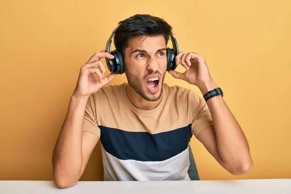 Jovem Homem Bonito Ouvindo Música Usando Fones Ouvido Irritado Louco — Fotografia de Stock