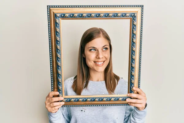 Mooie Blanke Vrouw Met Een Leeg Frame Glimlachend Naar Zijkant — Stockfoto