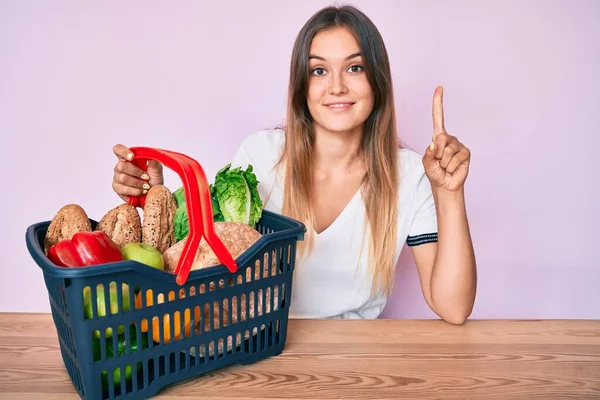 Beautiful Caucasian Woman Holding Supermarket Shopping Basket Smiling Idea Question — Stock Photo, Image