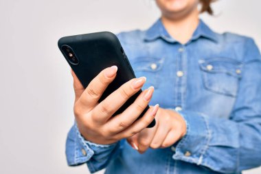 Beyaz arka plan üzerinde akıllı telefon kullanan genç beyaz bir kadın.