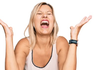 Orta yaşlı beyaz kadın, sıradan kıyafetler giyip başarıyı kutluyor. Kolları havada, gözleri kapalı, heyecanlı çığlıklar atıyorlar. Kazanan konsept 