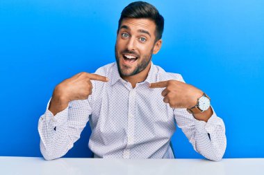 Yakışıklı, iş kıyafetleri giyen, kendine güvenen, gülümseyen, kendini gururlu ve mutlu gösteren bir adam.. 