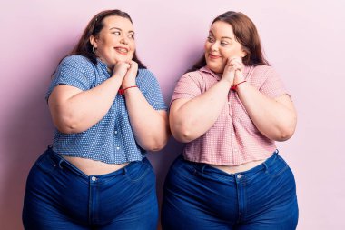 Genç ve cüsseli ikizler gündelik kıyafetler giyip gergin ve heyecanlı bir şekilde çene kenarlarına bakıyor. 