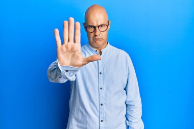 Orta yaşlı, kel, günlük kıyafetler giyen ve gözlüklü bir adam avucunun içi gibi şarkı söylemeyi kesiyor. Yüzünde olumsuz ve ciddi bir jest olan uyarı ifadesi. 