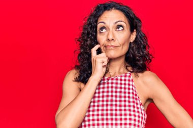 Orta yaşlı, kolsuz tişört giyen güzel bir kadın şüpheye odaklanmış, çenesinde parmak olan ve kafasını kaldırıp merak eden biri. 