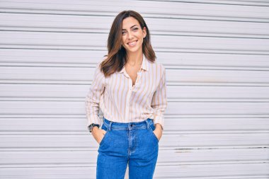 Genç İspanyol kadın gülümseyerek şehirde mutlu mesut yürüyor..