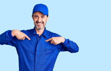 Orta yaşlı, yakışıklı, tamirci üniforması giyen, kendine güvenen, gülümseyen, kendini gururlu ve mutlu gösteren bir adam.. 