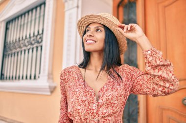 Genç Afro-Amerikan turist kadın tatilde gülümseyerek şehirde mutlu bir şekilde yürüyor..