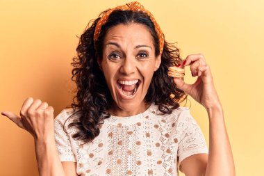 Orta yaşlı, güzel bir kadın. Makarnayı elinde tutuyor. Parmağını yana doğru uzatıyor. 