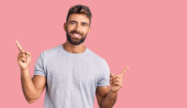 Gündelik kıyafetler giyen, kendine güvenen, parmaklarını farklı yönlere çeviren genç İspanyol adam. reklam için kopyalama alanı 