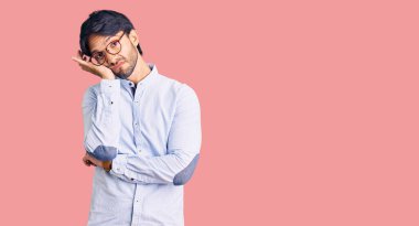 İş gömleği ve gözlük takan yakışıklı İspanyol, kollarını kavuşturarak depresyondan sıkılmış ve yorgun göründüğünü düşünüyor.. 