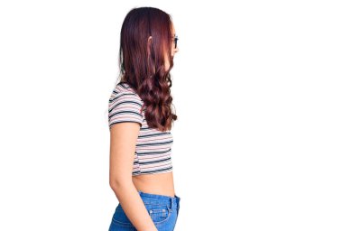 Genç, güzel Çinli bir kız, günlük giysiler giymiş, rahat bir görünüm takınıyor, doğal bir yüz ifadesi ve kendine güvenen bir gülümsemeyle poz veriyor.. 