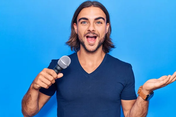 Joven Hombre Guapo Cantando Canción Usando Micrófono Celebrando Logro Con —  Fotos de Stock