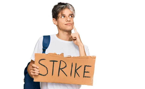 Young Hispanic Man Holding Strike Banner Cardboard Serious Face Thinking — Stock Photo, Image