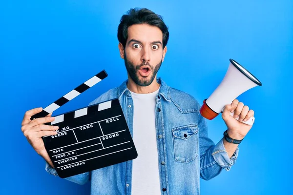 Giovane Uomo Ispanico Possesso Video Film Clapboard Megafono Spaventato Scioccato — Foto Stock