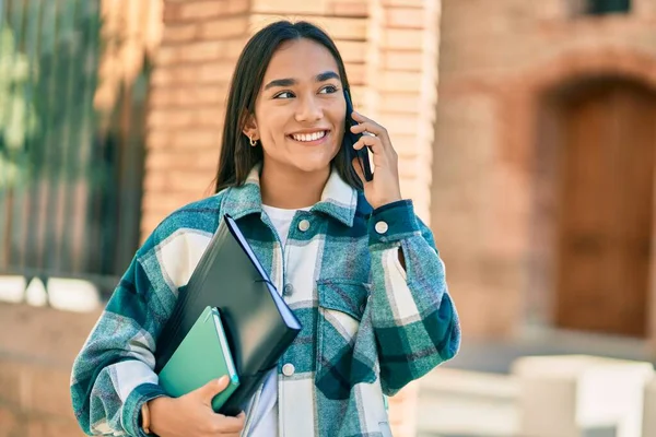 若いですラテン語学生女の子笑顔幸せな使用スマートフォンで市内 — ストック写真