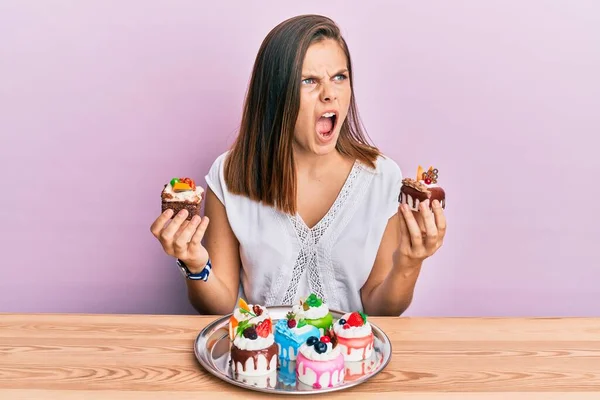 Young Caucasian Woman Holding Cake Slices Angry Mad Screaming Frustrated — Stock Photo, Image