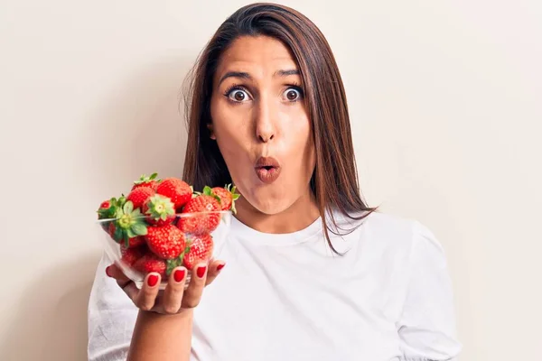 Young Beautiful Brunette Woman Holding Bowl Strawberries Scared Amazed Open — Stock fotografie