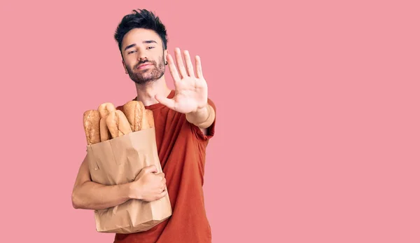 Young Hispanic Man Holding Paper Bag Bread Open Hand Doing — Stock Photo, Image