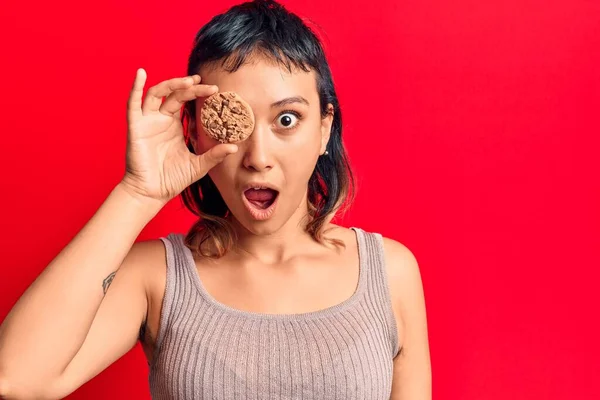 Jovem Segurando Biscoito Assustado Surpreso Com Boca Aberta Para Surpresa — Fotografia de Stock