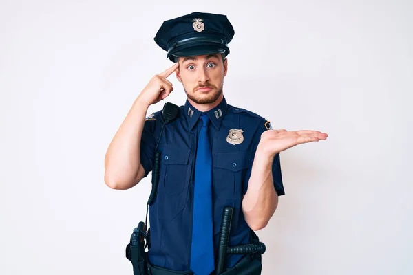 Mladý Běloch Policejní Uniformě Zmatený Otrávený Otevřenou Dlaní Ukazující Místo — Stock fotografie