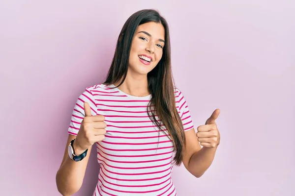Młoda Brunetka Ubrana Luźne Ubrania Różowym Tle Znak Sukcesu Robi — Zdjęcie stockowe