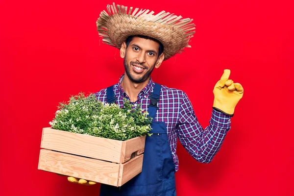 Çiftçilik Şapkası Önlük Takan Genç Latin Adam Saksıyı Tutarken Gülümsüyor — Stok fotoğraf