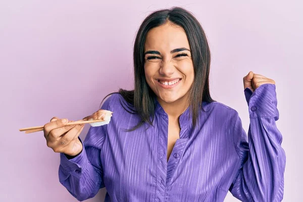 Giovane Donna Bruna Mangiare Sushi Nigiri Utilizzando Bacchette Urlando Orgoglioso — Foto Stock