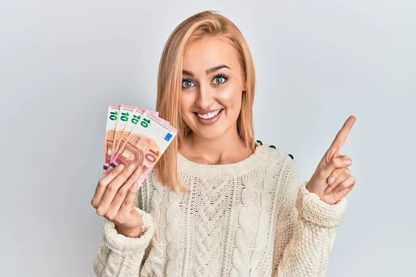 Hermosa Mujer Rubia Caucásica Sosteniendo Billetes Euros Sonriendo Feliz Señalando — Foto de Stock