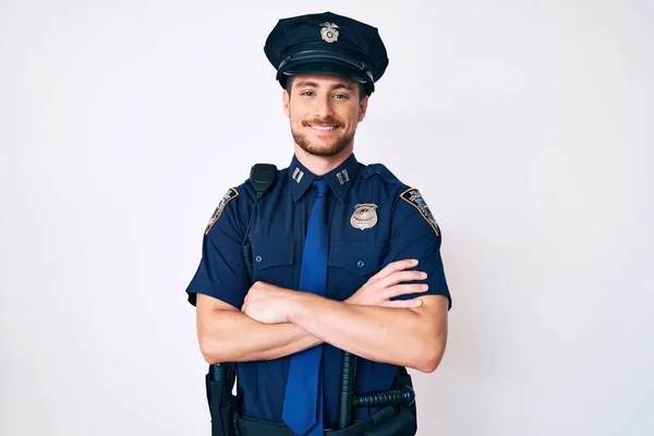 Ung Hvid Mand Iført Politiuniform Glad Ansigt Smilende Med Krydsede - Stock-foto