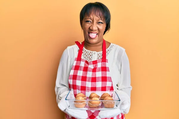Afroamerikanerin Mittleren Alters Bäckerschürze Mit Muffins Die Zunge Herausstreckend Mit — Stockfoto