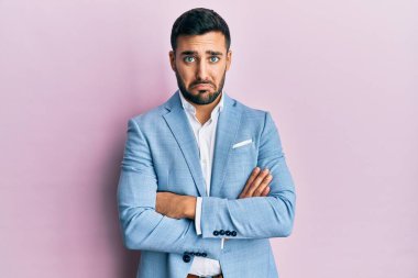 Kollarını kavuşturmuş genç İspanyol iş adamı depresif ve endişeli, sinirli ve korkmuş bir şekilde ağlıyor. hüzünlü ifade. 