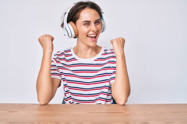 Masada oturmuş gururla haykıran, zaferi kutlayan ve kollarını kaldırarak heyecanla bekleyen Latin asıllı genç bir kadın. 