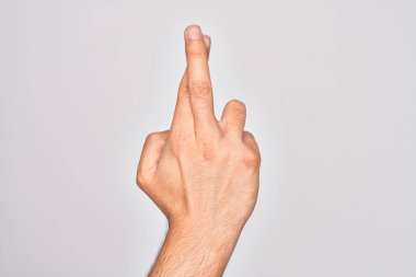 İzole edilmiş beyaz arka planda parmaklarını gösteren beyaz tenli bir gencin eli. Parmakları çapraz, batıl inançlar ve şanslı bir jest, şanslı ve umut dolu bir ifade.