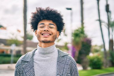 Genç Afrikalı Amerikalı iş adamı şehirde mutlu mesut dikiliyor..