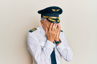 Yakışıklı, olgun, uçak pilotu üniforması giyen, suratını ellerle örten ve ağlayan bir adam. depresyon kavramı. 