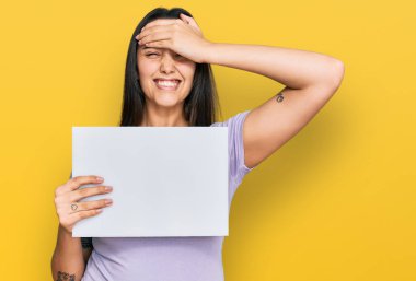 Elinde boş pankart tutan genç İspanyol kadın. Elleri kafasında, şaşırmış ve kızgın bir yüzle stresli ve sinirli. 