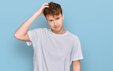 Gündelik beyaz t-shirt giyen genç beyaz adam soru sormayı merak ediyor. Şüpheyle kararsız, kafa kafaya düşünerek. Düşünceli kavram. 