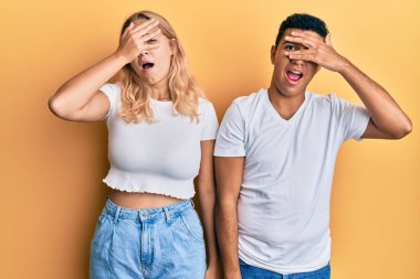 Irklar arası genç bir çift günlük beyaz tişört giyiyor. Şok geçiriyorlar, yüzlerini ve gözlerini kapatıyorlar. Utanmış bir ifadeyle parmaklarından bakıyorlar.. 