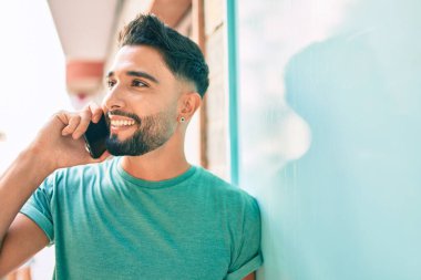 Şehirdeki akıllı telefondan konuşan, ciddi bir suratı olan genç bir Arap..