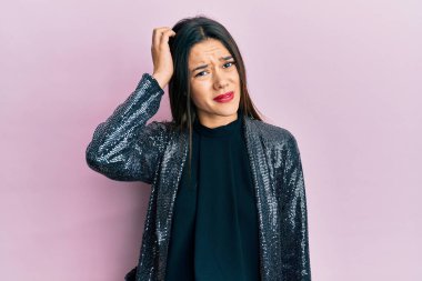 Young hispanic girl wearing party jacket confuse and wonder about question. uncertain with doubt, thinking with hand on head. pensive concept. 