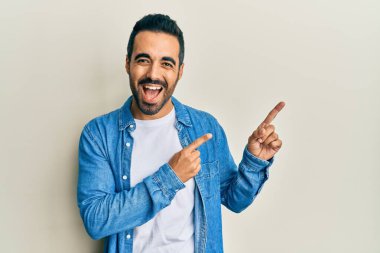 Genç İspanyol adam parmaklarıyla kendini göstererek gülüyor ve kahkahalarla gülüyor.. 