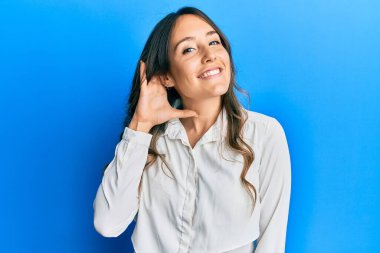 Genç esmer kadın, gündelik kıyafetler giyip sırıtarak kulaklarını açıp dedikodu ve dedikoduları dinliyor. Sağırlık kavramı. 