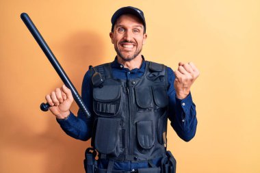 Üniforma giyen yakışıklı polis ve sarı arka planda baston tutan kurşuncu gururla bağırıyor, zaferi ve başarıyı kutluyor.